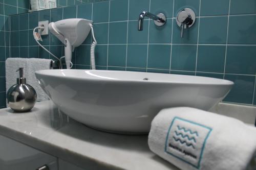 a white sink in a bathroom with blue tiles at Beachfront Apartment Nazaré in Nazaré