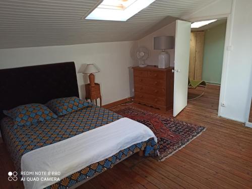 een slaapkamer met een bed en een dressoir bij terre et mer in Sainte-Ramée