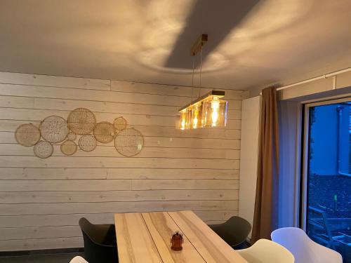 a dining room with a wooden table and a wall at Au p’tit loup in Bastogne