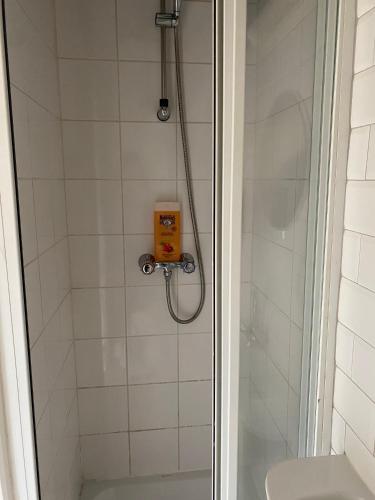 La salle de bains est pourvue d'une douche et d'un distributeur de savon jaune. dans l'établissement Studio plein coeur de Nice 24 24H 7 7J, à Nice