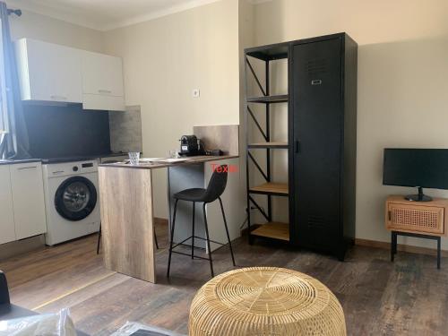 une petite cuisine avec une table et un réfrigérateur noir. dans l'établissement Studio plein coeur de Nice 24 24H 7 7J, à Nice