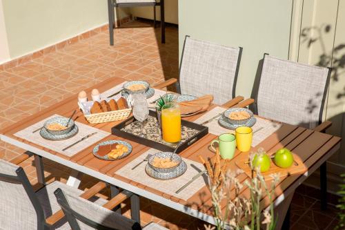 a wooden table with food and orange juice on it at George's Home in Vasiliki