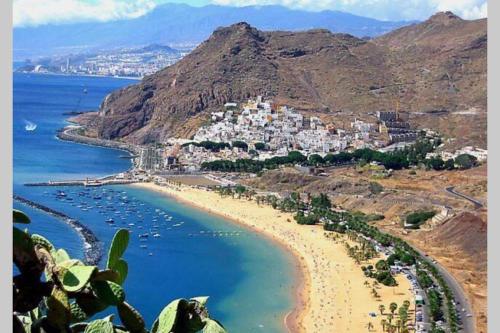 a view of a beach with a town on a hill at Vacation Home Studio Los Cristianos in Arona