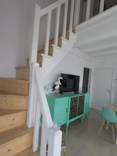 a living room with a green desk and stairs at Recantus Comporta in Comporta