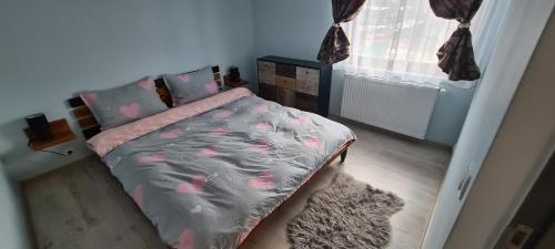 a bedroom with a bed with pink flowers on it at Comfort Home Studio in Petroşani
