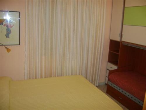 オートラントにあるAppartamento a Otranto con Vista Mareのベッドルーム(黄色のベッド1台、赤い椅子付)