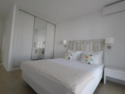 a white bedroom with a large white bed with pillows at Recantus Comporta in Comporta