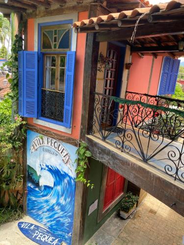 a building with a painting on the side of it at Vila Pequeá Pousada Ilhabela in Ilhabela