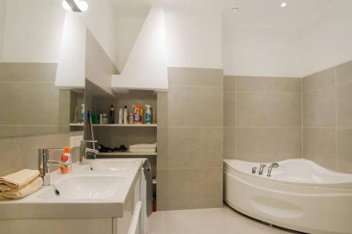 Baño blanco con bañera y lavamanos en Modern & Spacious 80m2 Apartment in Riga Old Town, en Riga
