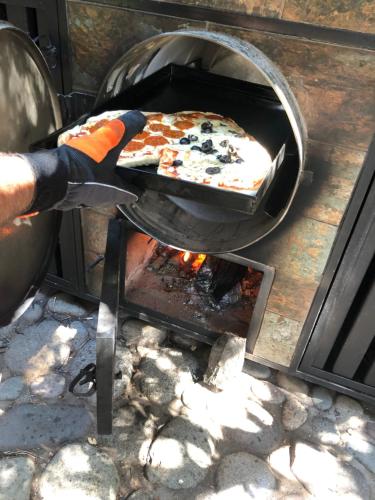 a pizza is being cooked in an oven at Casa de Montaña inmersa en Bosque Nativo in San José de Maipo