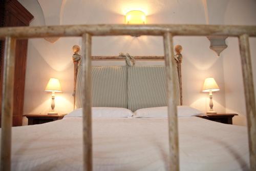 a bedroom with a bed with two lamps on both sides at Castello Vicchiomaggio in Greve in Chianti