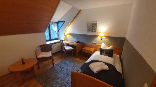 ein Schlafzimmer mit einem Bett und einem Schreibtisch in einem Zimmer in der Unterkunft Landhaus Langeck in Münstertal