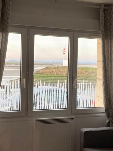 Cette chambre dispose d'une porte avec trois fenêtres et d'un phare. dans l'établissement Studio Quai Blavet, à Saint-Valery-sur-Somme