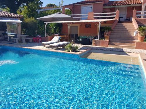 une grande piscine bleue devant une maison dans l'établissement Escapades en provence, à Saint-Zacharie