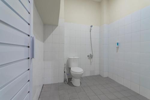 a white bathroom with a toilet and a shower at RedDoorz near Trans Studio Bandung 3 in Bandung