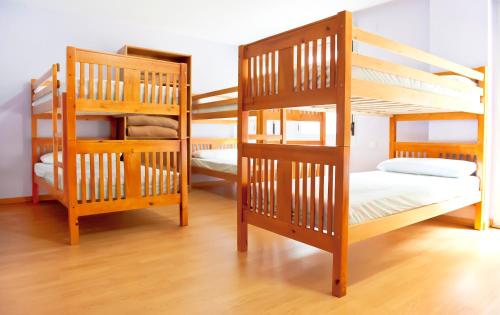 2 łóżka piętrowe w pokoju z drewnianą podłogą w obiekcie Albergue Turístico Rio Aragon w mieście Canfranc-Estación