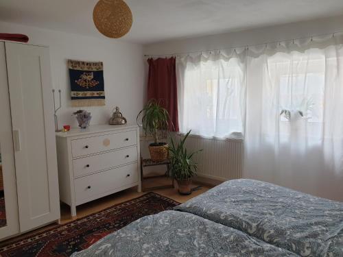 a bedroom with a bed and a dresser and a window at Unser Obervolkacher Ferienhaus-einfach gemütlich! in Volkach