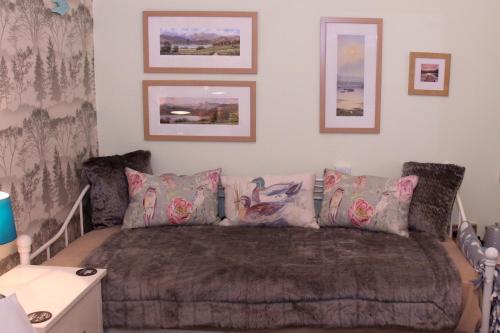 a bedroom with a couch and pillows on a bed at Invergarry Room Only Guest House For Adults in Windermere