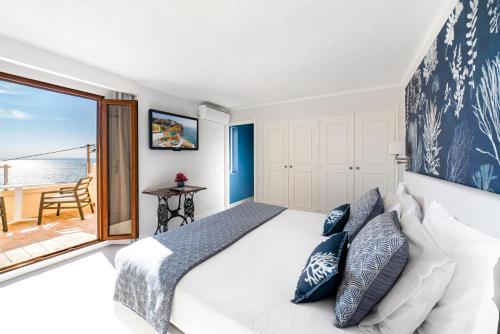 a bedroom with a bed with a view of the ocean at Castelo Guest House in Carvoeiro