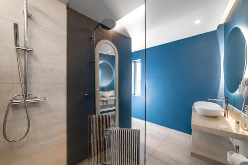 a bathroom with blue walls and a sink and a shower at Castelo Guest House in Carvoeiro