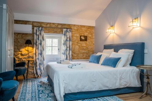 een blauwe en witte slaapkamer met een groot bed bij Château Haut-Clarise in Belvès-de-Castillon