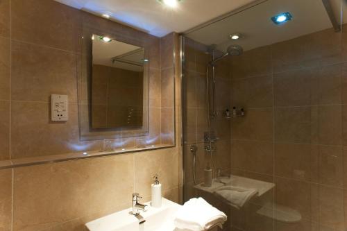 a bathroom with a sink and a shower and a mirror at Nearwater in Saint Mawes