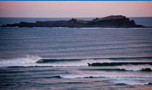 a body of water with waves and a rocky island at Mundaka Vista Mar L-BI-52 in Mundaka