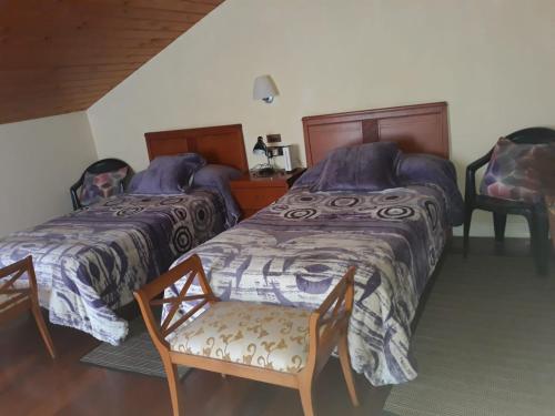 a bedroom with two beds and a chair at Mundaka Vista Mar L-BI-52 in Mundaka