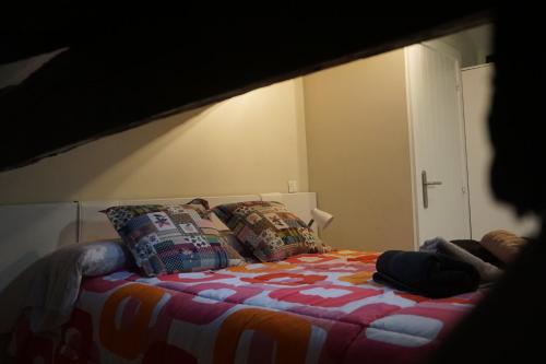 a bedroom with a bed with colorful blankets and pillows at ATICO TORRONTERO in Mundaka