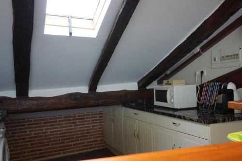 a kitchen with a window and a microwave on a counter at ATICO TORRONTERO in Mundaka