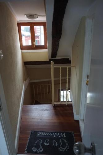 a hallway with a staircase with a window and a rug at ATICO TORRONTERO in Mundaka