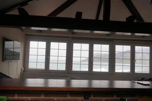 a group of windows in a room with a table at ATICO TORRONTERO in Mundaka