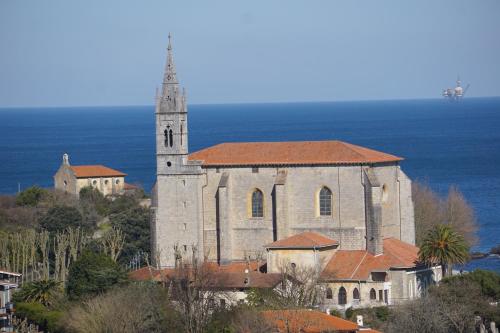 an old church with a steeple on a hill at ATICO TORRONTERO in Mundaka