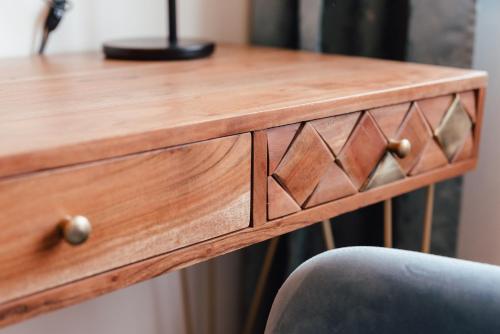 a wooden desk with a wooden drawer with a chair at Smarthotel Völkermarkt in Völkermarkt