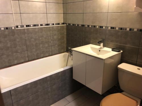 La salle de bains est pourvue d'un lavabo, de toilettes et d'une baignoire. dans l'établissement Studio Belle Hutte 2, à La Bresse