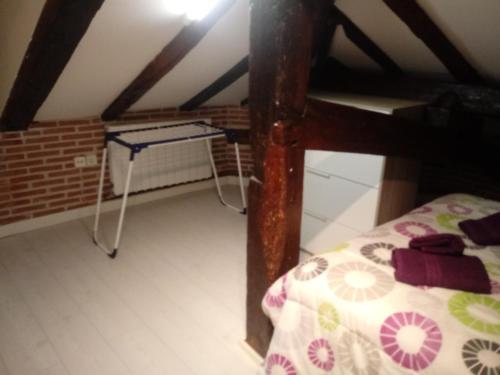 a room with a bed and a table in a attic at ATICO TORRONTERO in Mundaka