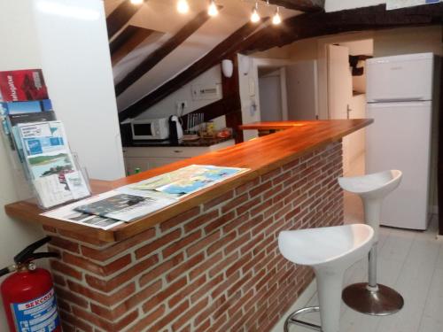 a kitchen with a brick counter with two stools at ATICO TORRONTERO in Mundaka