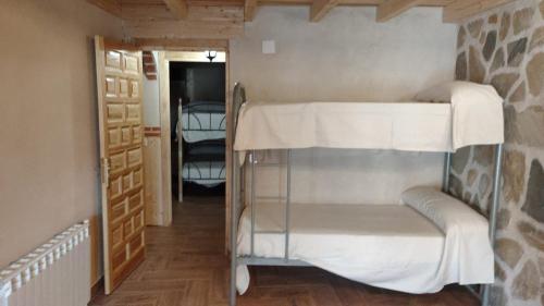 Divstāvu gulta vai divstāvu gultas numurā naktsmītnē Casa Rural Baños de la Reina con piscina climatizada