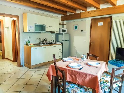 Una cocina y un comedor con mesa y sillas. en Appartamenti San Francesco, en Lazise