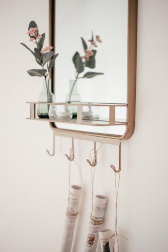 a shelf with two vases and a mirror on a wall at Smarthotel Völkermarkt in Völkermarkt