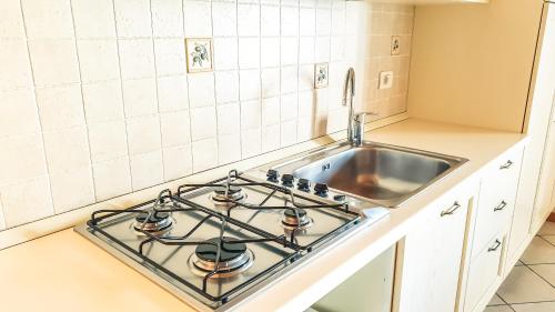 una cocina con estufa horno superior al lado de un fregadero en Appartamenti San Francesco, en Lazise