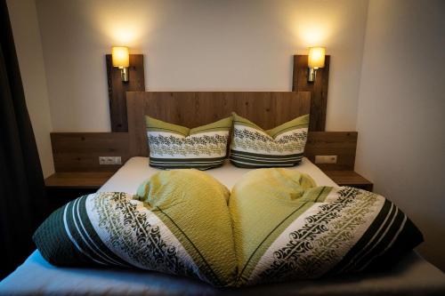 a bed with two pillows on top of it at Landhaus Steinmüller in Längenfeld
