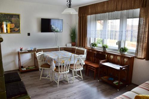 a kitchen and dining room with a table and chairs at Pesti Vendégház Zalalövő in Zalalövő