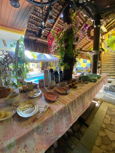 a long table with plates of food on it at Morada do Aventureiro in Angra dos Reis