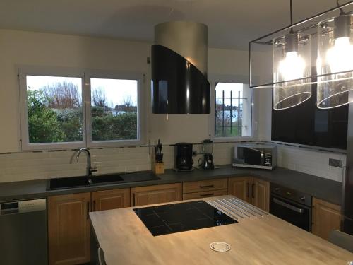 - une cuisine avec un comptoir et 2 fenêtres dans l'établissement MAISON LES PIEDS DANS L EAU, à Roscoff