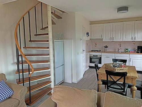 a kitchen and a living room with a spiral staircase at Christinahoeve Hooiberg #6 in Boskoop