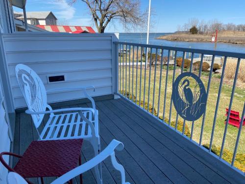a porch with a bench and a view of the water at Tilghman Island Inn in Tilghman Island