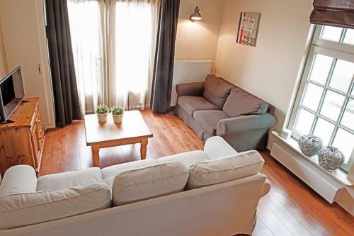 a living room with a couch and a table at Christinahoeve Hooiberg #5 in Boskoop
