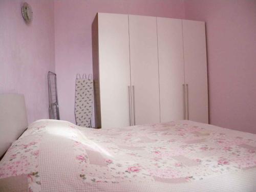 1 dormitorio con 1 cama con paredes de color rosa y armarios blancos en Apartment in Rijeka 36068 en Rijeka