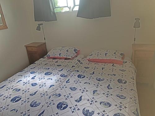 1 cama con edredón y almohadas azules y blancos en Christinahoeve Hooiberg #6, en Boskoop